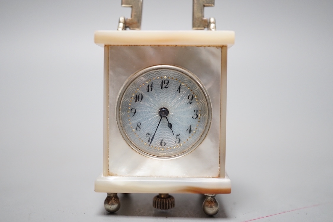 A miniature Swiss mother of pearl timepiece, engraved Brevet above a cross and numbered 33817, 4 cms high.
